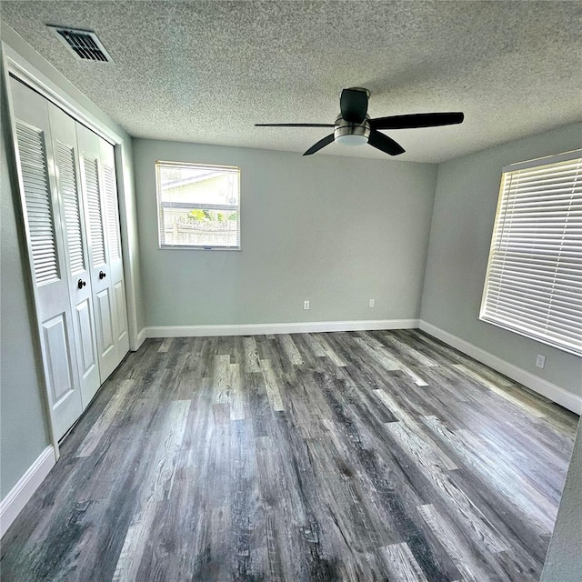 6008 Firefly Ln, Apollo Beach, FL 33572 - unfurnished bedroom featuring wood finished floors, a closet, a ceiling fan, and a textured ceiling