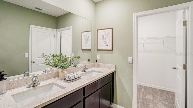 583 Mangrove Shade Cir, Apollo Beach, FL 33572 - bathroom featuring double vanity, a spacious closet, and baseboards
