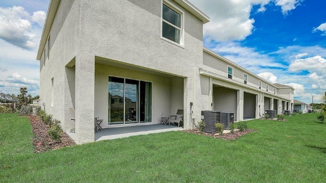 583 Mangrove Shade Cir, Apollo Beach, FL 33572 - back of house featuring central AC, stucco siding, a patio area, and a lawn