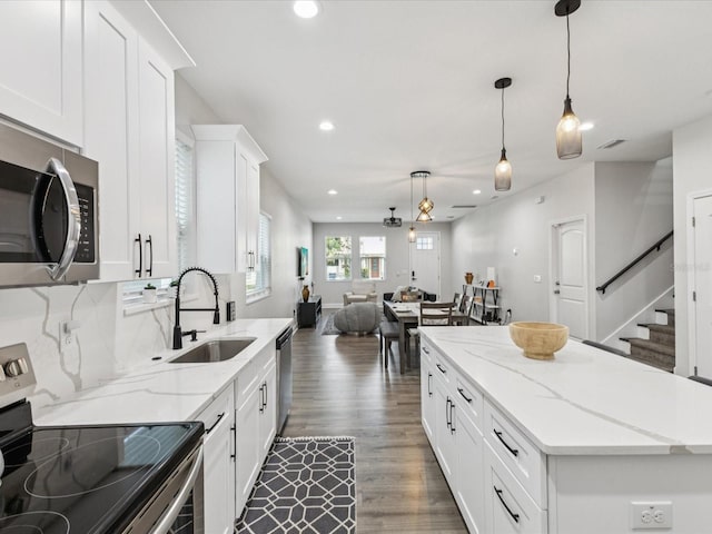 2809 N 21st St, Tampa, FL 33605 - kitchen featuring appliances with stainless steel finishes, wood finished floors, recessed lighting, a kitchen island, and open floor plan