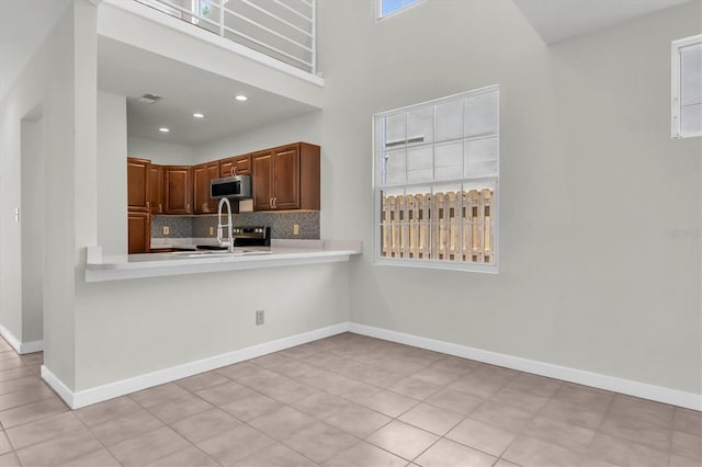 3412 W San Juan St Unit A, Tampa, FL 33629 - kitchen with stainless steel microwave, tasteful backsplash, light countertops, light tile patterned flooring, and recessed lighting