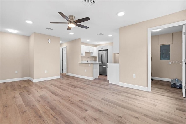 21536 Holdern Ave, Port Charlotte, FL 33952 - unfurnished living room with electric panel, ceiling fan, light wood-style floors, baseboards, and recessed lighting