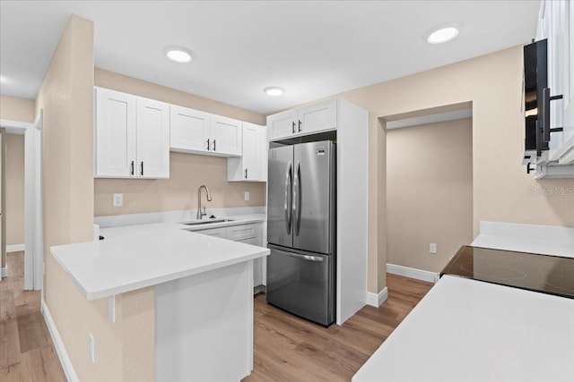 21536 Holdern Ave, Port Charlotte, FL 33952 - kitchen featuring freestanding refrigerator, a sink, light wood-style flooring, and white cabinets