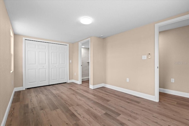 21536 Holdern Ave, Port Charlotte, FL 33952 - unfurnished bedroom featuring wood finished floors, baseboards, and a closet