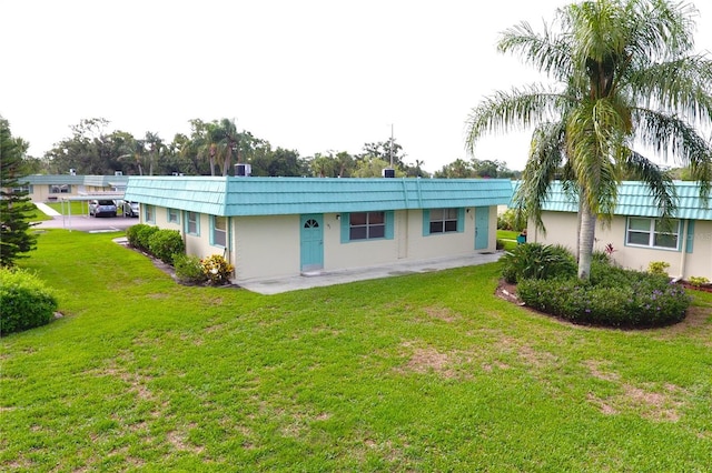 101 Cambridge Trl Unit 194, Sun City Center, FL 33573 - rear view of house featuring a lawn and stucco siding
