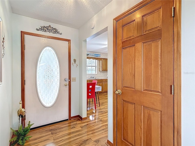 5755 Yorkshire Dr, Zephyrhills, FL 33542 - entrance foyer with light wood-type flooring and a textured ceiling