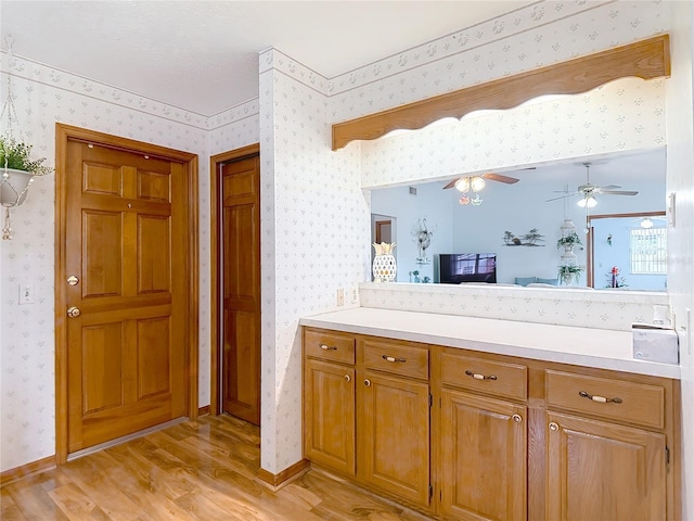 5755 Yorkshire Dr, Zephyrhills, FL 33542 - bathroom with wallpapered walls, wood finished floors, vanity, and a ceiling fan