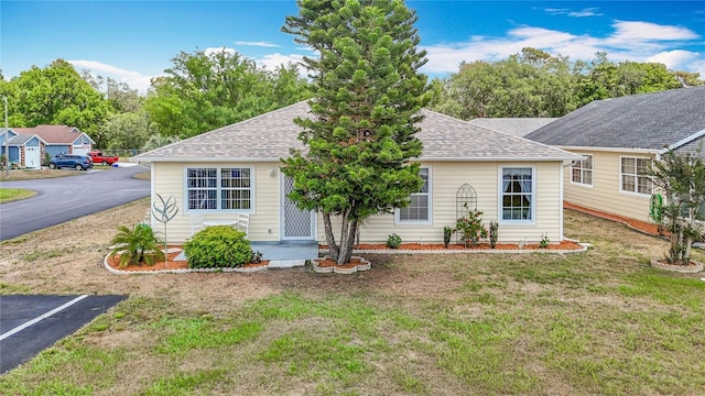 5755 Yorkshire Dr, Zephyrhills, FL 33542 - view of front of house with a front lawn, a shingled roof, and uncovered parking