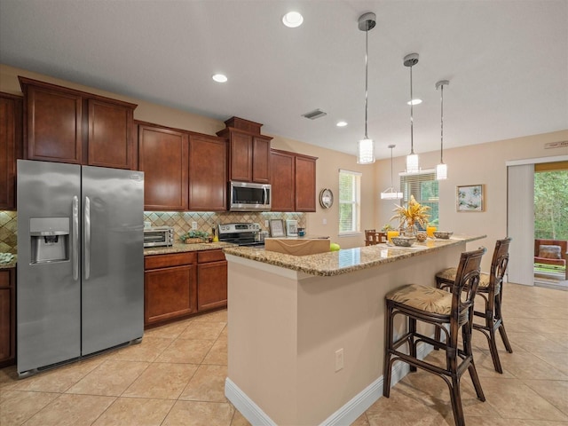 27546 Stonecreek Way, Wesley Chapel, FL 33544 - kitchen featuring appliances with stainless steel finishes, decorative backsplash, light tile patterned floors, light stone counters, and recessed lighting