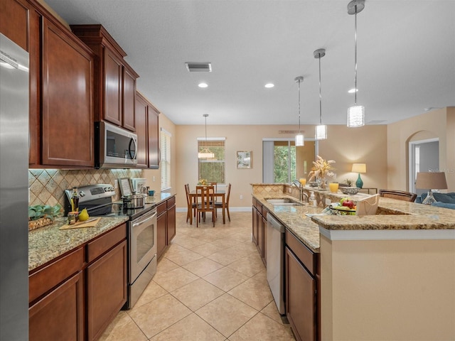 27546 Stonecreek Way, Wesley Chapel, FL 33544 - kitchen with stainless steel appliances, recessed lighting, light tile patterned floors, backsplash, and decorative light fixtures