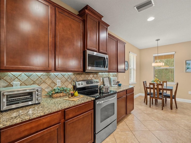 27546 Stonecreek Way, Wesley Chapel, FL 33544 - kitchen with appliances with stainless steel finishes, decorative backsplash, light stone countertops, light tile patterned flooring, and recessed lighting