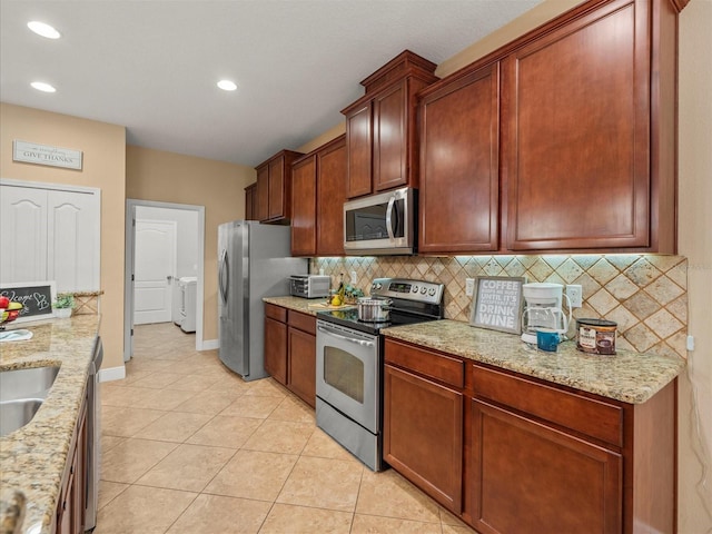27546 Stonecreek Way, Wesley Chapel, FL 33544 - kitchen with stainless steel appliances, light tile patterned floors, decorative backsplash, recessed lighting, and light stone countertops