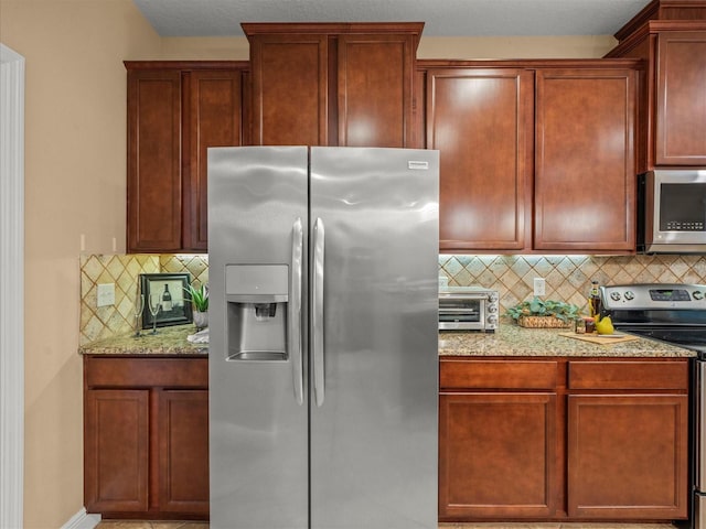 27546 Stonecreek Way, Wesley Chapel, FL 33544 - kitchen featuring stainless steel appliances, backsplash, and light stone countertops
