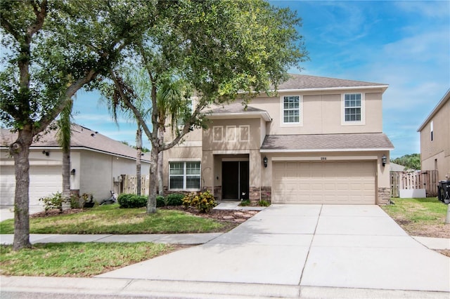 5916 Tulip Flower Dr, Riverview, FL 33578 - view of front facade with stucco siding, driveway, stone siding, and an attached garage