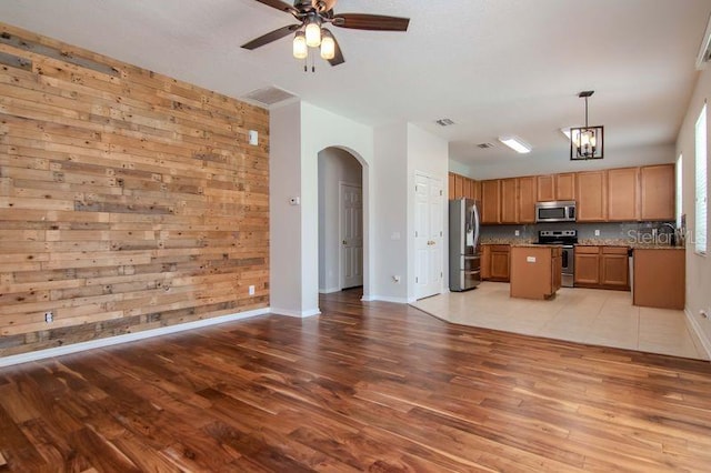 5916 Tulip Flower Dr, Riverview, FL 33578 - kitchen with appliances with stainless steel finishes, arched walkways, open floor plan, light wood-type flooring, and a ceiling fan