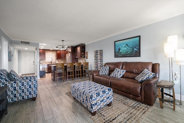 1230 Gulf Blvd Unit 304, Clearwater, FL 33767 - living area featuring crown molding, light wood-type flooring, and baseboards