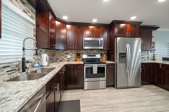 1230 Gulf Blvd Unit 304, Clearwater, FL 33767 - kitchen with appliances with stainless steel finishes, a sink, backsplash, light stone counters, and light wood finished floors