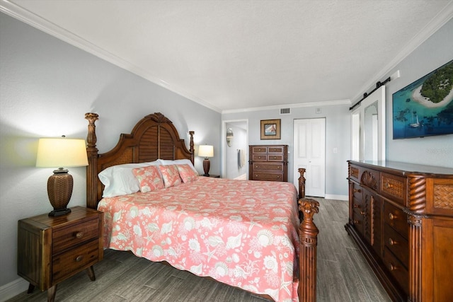 1230 Gulf Blvd Unit 304, Clearwater, FL 33767 - bedroom featuring dark wood-style flooring, ornamental molding, a barn door, baseboards, and a closet