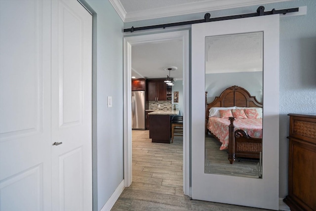 1230 Gulf Blvd Unit 304, Clearwater, FL 33767 - bedroom featuring freestanding refrigerator, light wood-style floors, ornamental molding, and a barn door