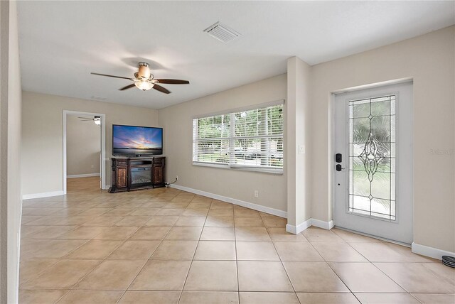11029 Clay Pit Rd, Tampa, FL 33610 - unfurnished living room featuring a ceiling fan, light tile patterned flooring, and baseboards
