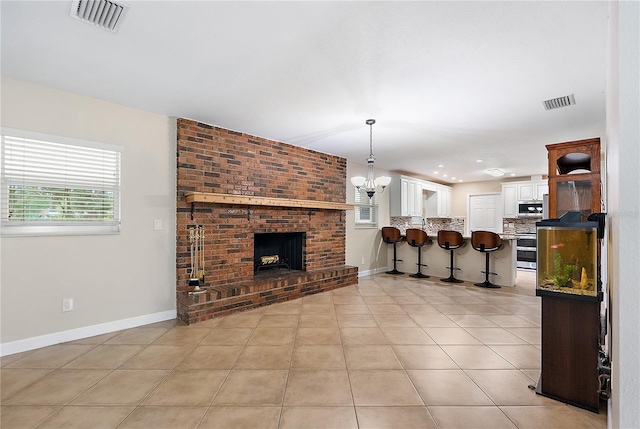 11029 Clay Pit Rd, Tampa, FL 33610 - living area featuring light tile patterned floors, a brick fireplace, baseboards, a chandelier, and recessed lighting