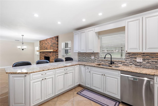 11029 Clay Pit Rd, Tampa, FL 33610 - kitchen with dishwasher, a peninsula, a sink, backsplash, and light tile patterned flooring