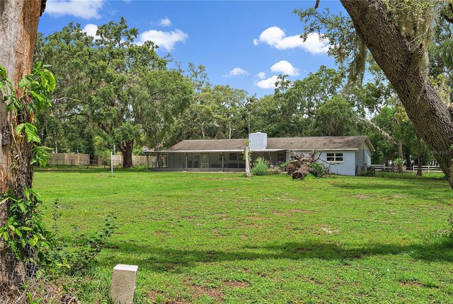 11029 Clay Pit Rd, Tampa, FL 33610 - view of yard featuring a sunroom and view of wooded area