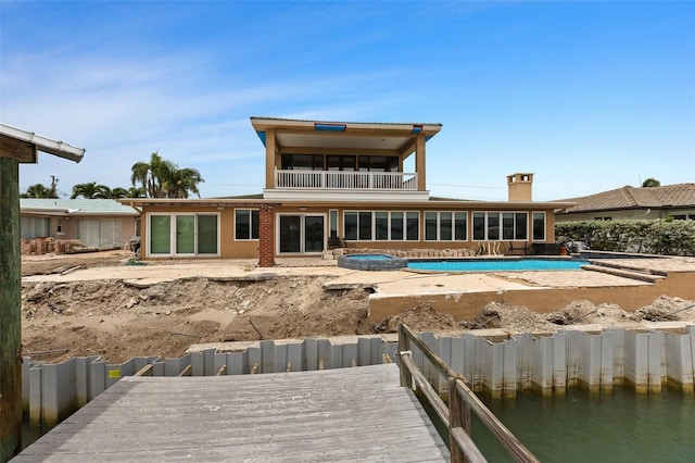 333 Midway Is, Clearwater Beach, FL 33767 - back of property with a balcony, an outdoor pool, and a patio area