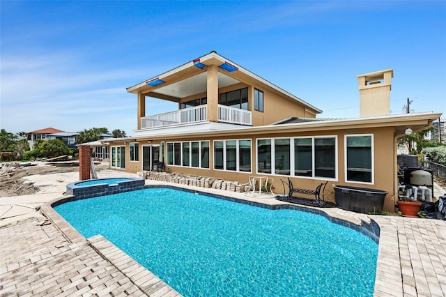 333 Midway Is, Clearwater Beach, FL 33767 - back of property featuring a balcony, a chimney, a pool with connected hot tub, and a patio area