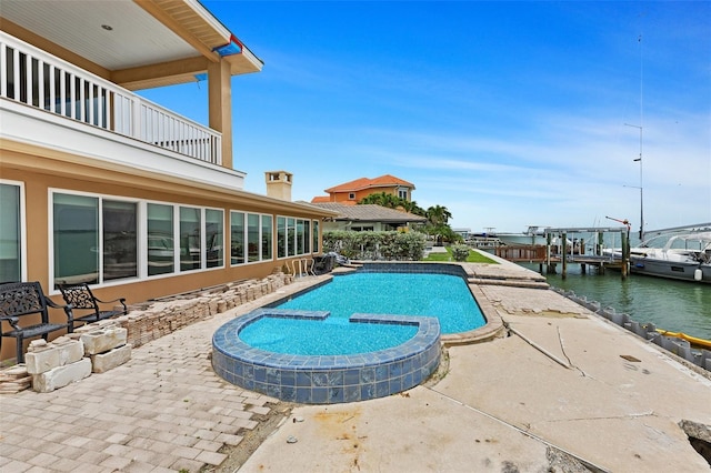 333 Midway Is, Clearwater Beach, FL 33767 - view of pool featuring a patio, a water view, and a pool with connected hot tub