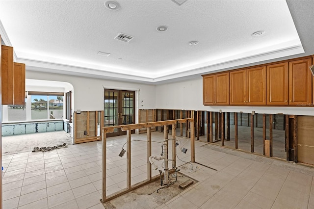 333 Midway Is, Clearwater Beach, FL 33767 - misc room featuring a raised ceiling, plenty of natural light, wainscoting, and a textured ceiling