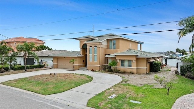 333 Midway Is, Clearwater Beach, FL 33767 - view of front facade with driveway, stucco siding, a garage, a tiled roof, and a front yard