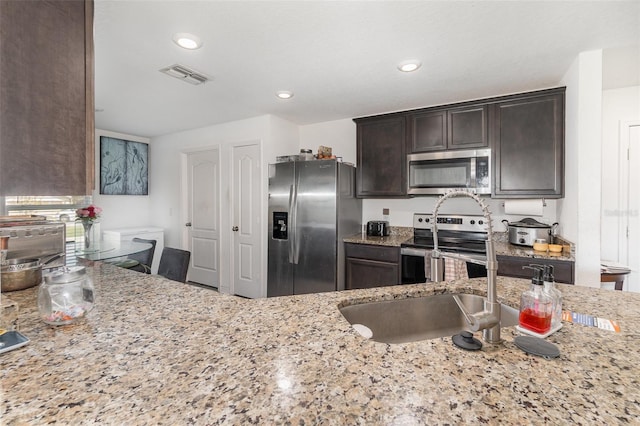 1741 Canaan Loop, Dundee, FL 33838 - kitchen featuring stainless steel appliances, dark brown cabinetry, light stone countertops, and recessed lighting