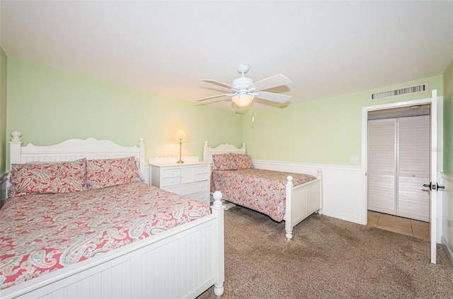 4450 Gulf Blvd Unit 110, St Pete Beach, FL 33706 - bedroom featuring light carpet, a wainscoted wall, and a ceiling fan