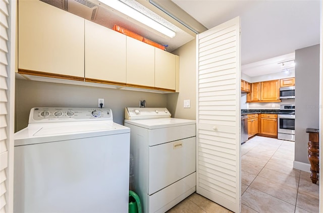 4450 Gulf Blvd Unit 110, St Pete Beach, FL 33706 - laundry room with cabinet space, washing machine and dryer, and light tile patterned flooring