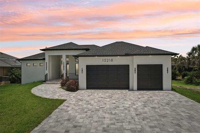 15218 Appleton Blvd, Port Charlotte, FL 33981 - prairie-style house with decorative driveway, an attached garage, stucco siding, a front yard, and a shingled roof