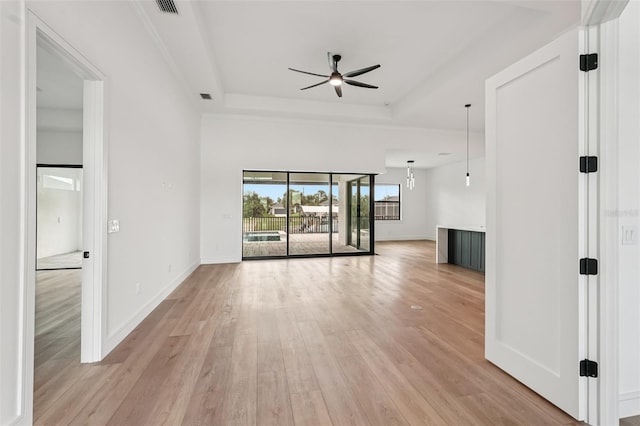 15218 Appleton Blvd, Port Charlotte, FL 33981 - unfurnished living room with ceiling fan, light wood-style floors, and a tray ceiling