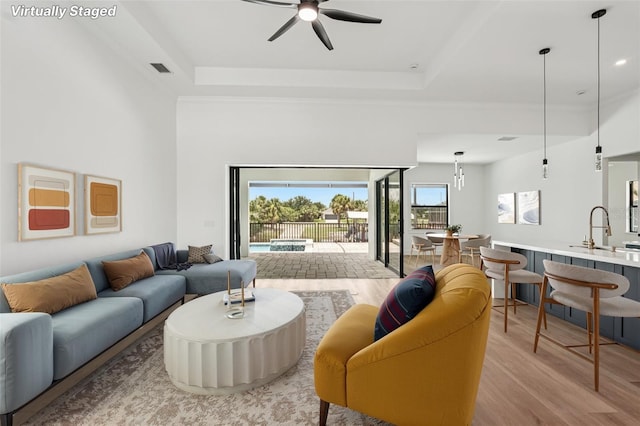 15218 Appleton Blvd, Port Charlotte, FL 33981 - living area with ceiling fan, light wood-style floors, and a raised ceiling