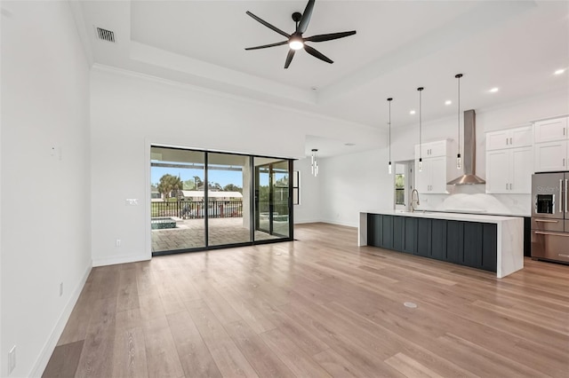 15218 Appleton Blvd, Port Charlotte, FL 33981 - unfurnished living room featuring a ceiling fan, light wood finished floors, a raised ceiling, and recessed lighting