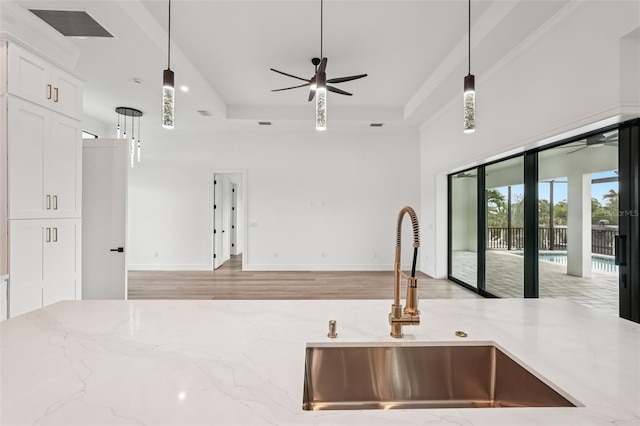 15218 Appleton Blvd, Port Charlotte, FL 33981 - kitchen featuring open floor plan, a ceiling fan, light stone counters, hanging light fixtures, and white cabinetry