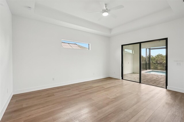 15218 Appleton Blvd, Port Charlotte, FL 33981 - empty room with a raised ceiling, light wood-style flooring, healthy amount of natural light, and ceiling fan