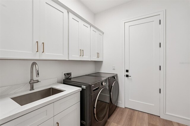 15218 Appleton Blvd, Port Charlotte, FL 33981 - laundry area featuring cabinet space, independent washer and dryer, and light wood-style floors