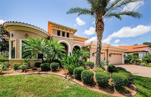 1012 Tuscany Dr, Trinity, FL 34655 - mediterranean / spanish home featuring a garage, stucco siding, driveway, and a tile roof