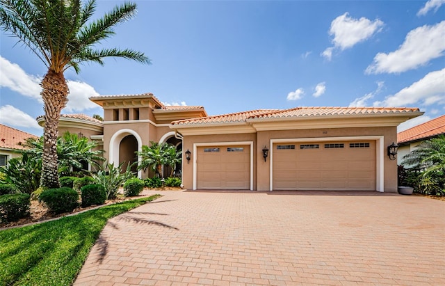 1012 Tuscany Dr, Trinity, FL 34655 - mediterranean / spanish house with decorative driveway, stucco siding, a garage, and a tile roof