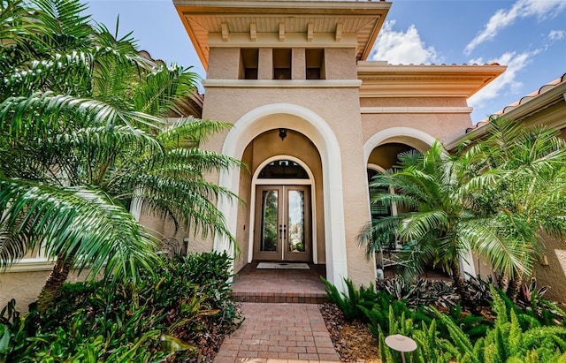 1012 Tuscany Dr, Trinity, FL 34655 - view of exterior entry with french doors and stucco siding