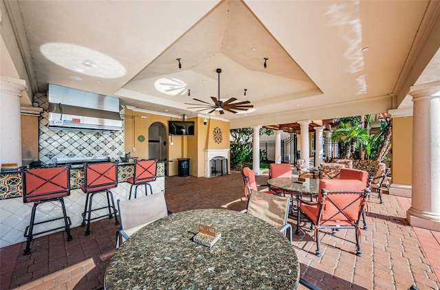 1012 Tuscany Dr, Trinity, FL 34655 - dining room with decorative columns, a tray ceiling, ceiling fan, and brick flooring