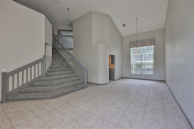 3633 Springville Dr, Valrico, FL 33596 - unfurnished living room with high vaulted ceiling, a chandelier, stairs, and tile patterned flooring