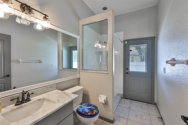 3633 Springville Dr, Valrico, FL 33596 - bathroom with a textured wall, toilet, vanity, a tile shower, and tile patterned flooring