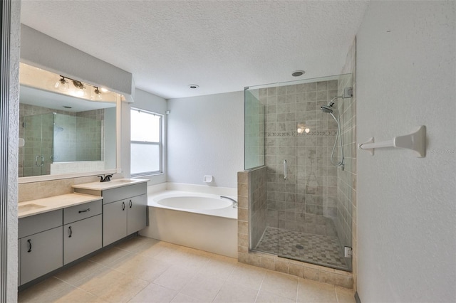3633 Springville Dr, Valrico, FL 33596 - full bathroom featuring a shower stall, a bath, double vanity, a textured ceiling, and tile patterned flooring