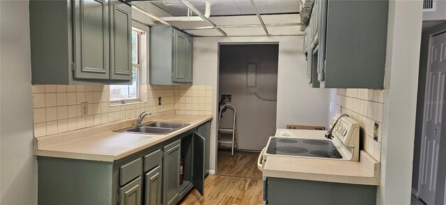 2503 Elm St, Seffner, FL 33584 - kitchen featuring a sink, green cabinetry, light wood finished floors, and decorative backsplash